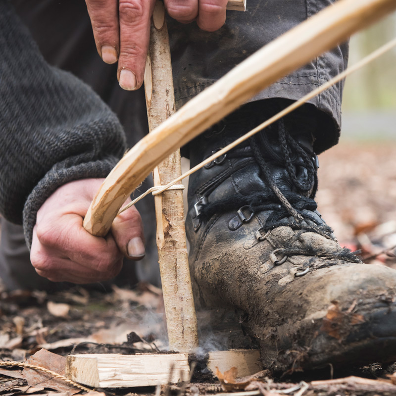 Friction fire lighting with a bow drill