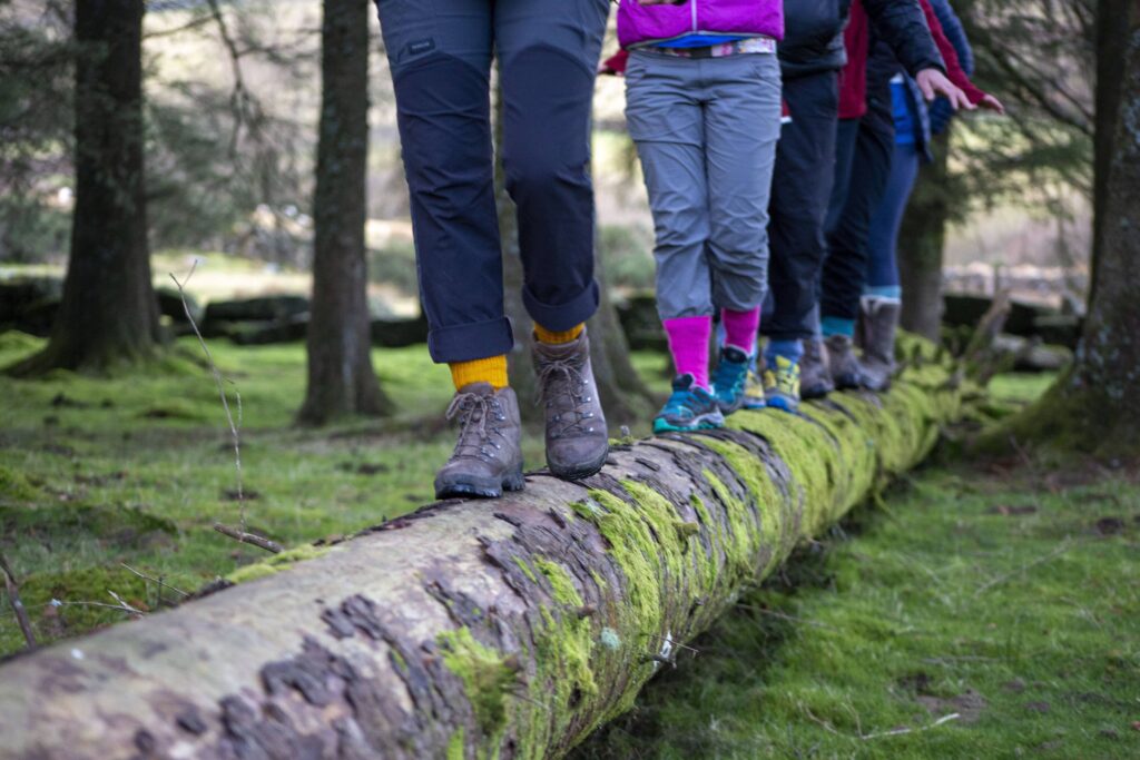 Five people along a fallen tree stump wearing corrymoor socks