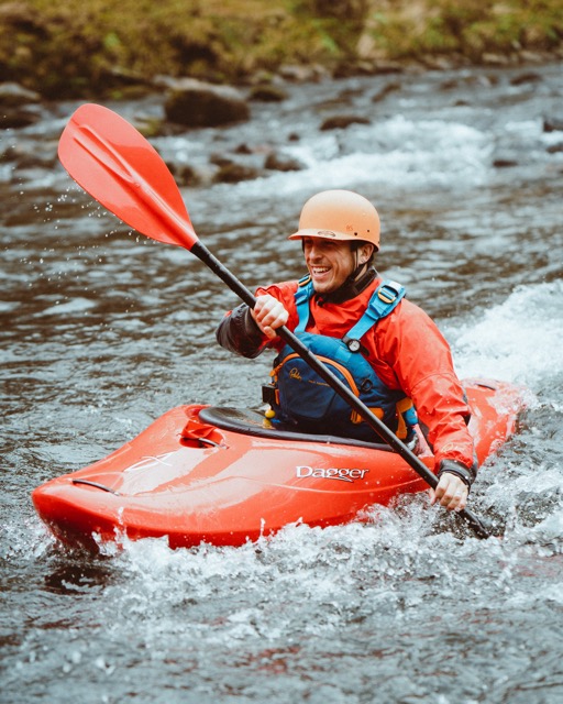 Outdoors instructor training, man on a kayak riding down white water rapids in Dartmoor