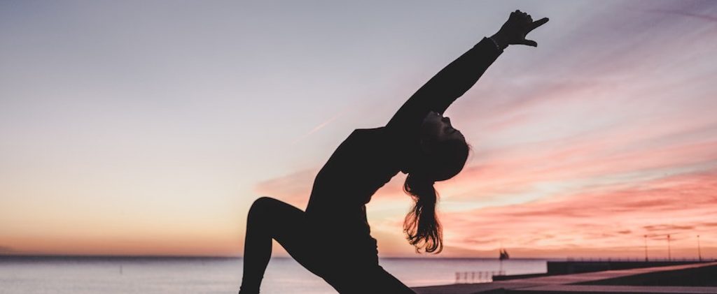 Instructor stretching on beach to avoid injury 