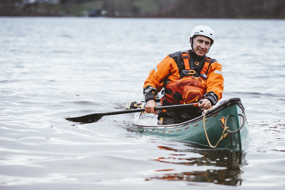 Outdoor kayak instructor going down a river